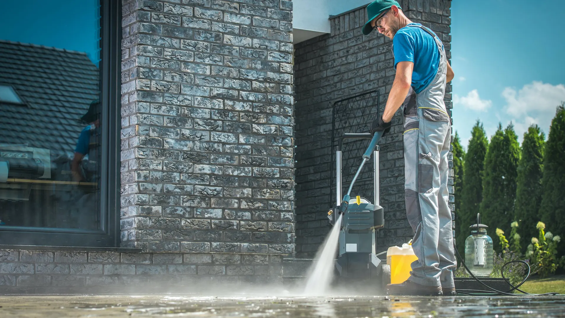 A man pressure washing the front of the house.