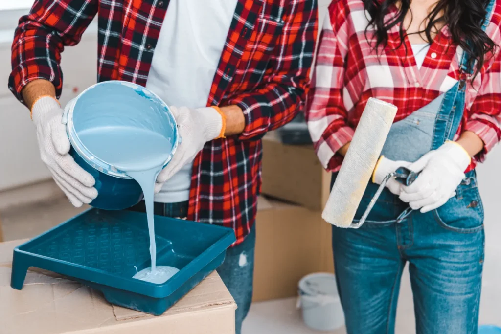 A couple carefully pouring the colored paint.