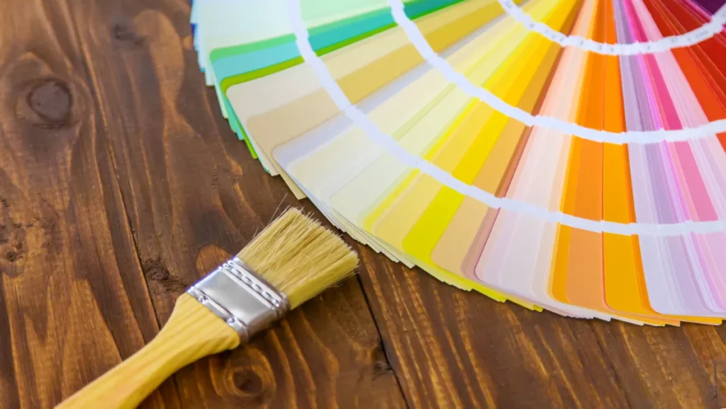 A brush a a color palette laying on the table.