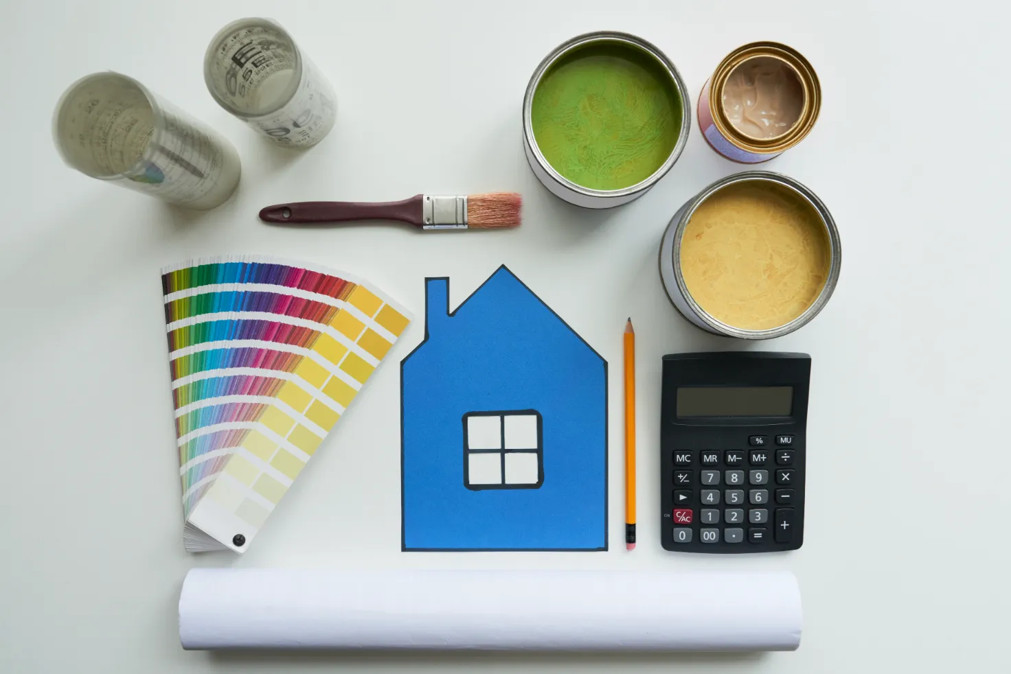 top view on a desk of palette colors with brushes, paint and calculator.