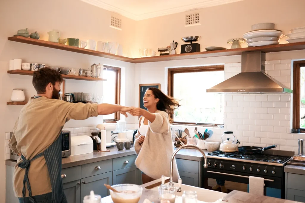 A happy couple dancing in the kitchen.