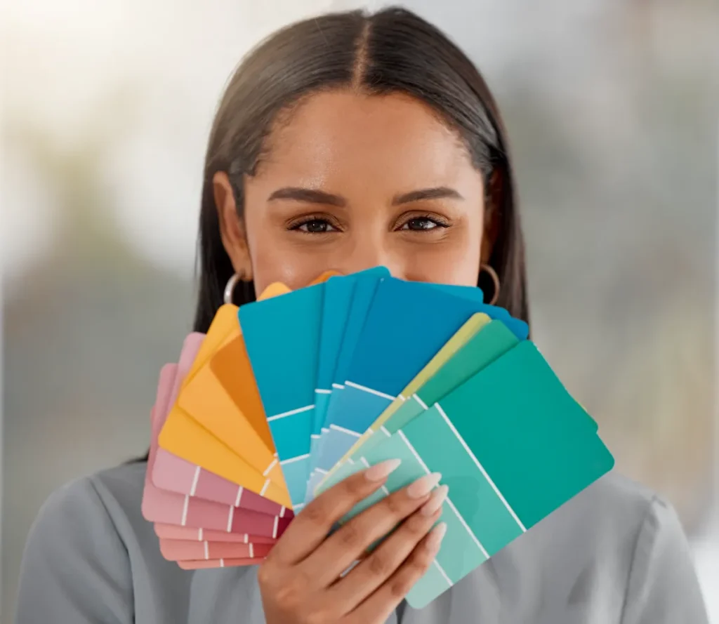 A young woman holding a different color swatches.