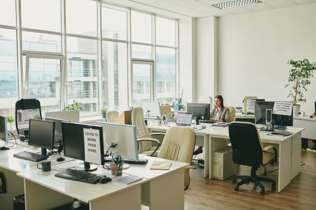 Young elegant businesswoman sitting by desk in an office.